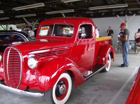 1970 Ford Ranchero - A bright red 1937 Ford pickup truck is parked indoors, with a "FOR SALE" sign visible in the window.