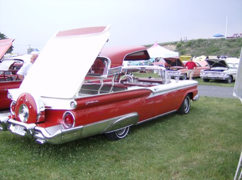 1970 Ford Ranchero - A red and white 1959 Ford Galaxie convertible is parked on grass with its trunk open, revealing a spare tire.