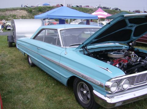 1970 Ford Ranchero - A light blue 1964 Ford Galaxie coupe is displayed with its hood open, revealing the engine bay.