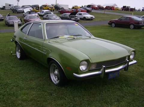 1970 Ford Ranchero - A green Ford Pinto is parked on a grassy field with other vehicles visible in the background.