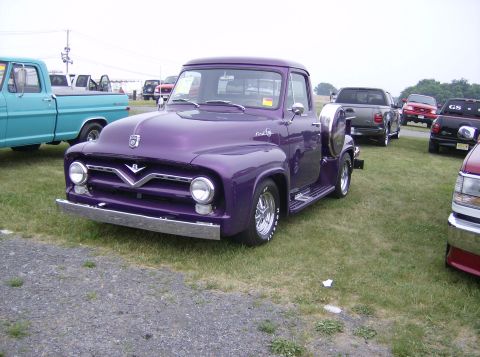 1970 Ford Ranchero - A custom purple 1955 Ford F-100 pickup truck is parked on a grassy field with other vehicles.