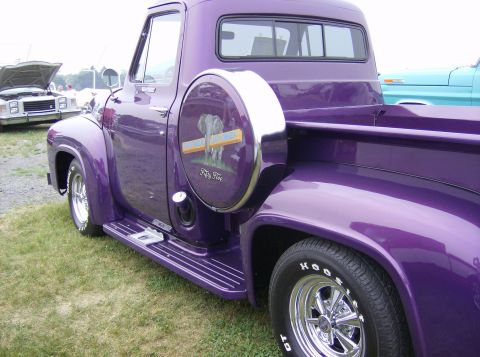 1970 Ford Ranchero - A custom purple 1955 Ford F-100 pickup truck is parked on grass, with another vehicle visible in the background.