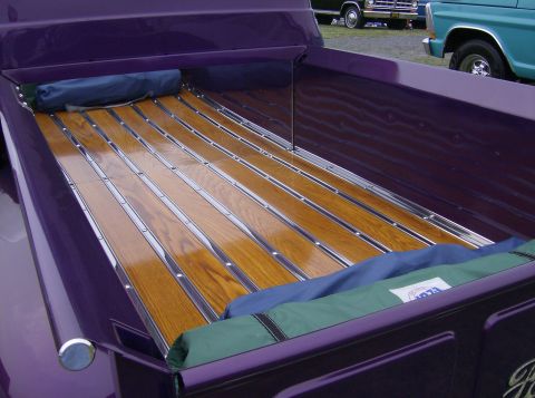 1970 Ford Ranchero - The bed of a purple pickup truck features a custom wood and metal slat floor. Other vehicles are visible in the background.