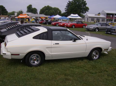 1970 Ford Ranchero - White coupe with black roof and louvers on rear window at an outdoor car show.