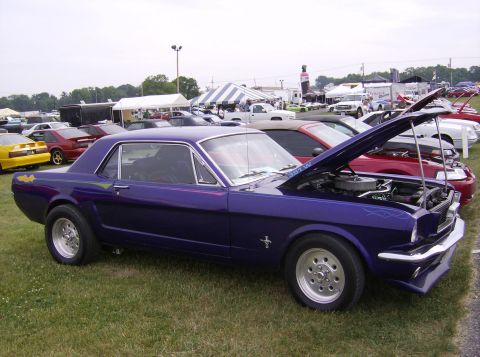 1970 Ford Ranchero - A purple 1965 Ford Mustang coupe is displayed with its hood open at an outdoor car show.