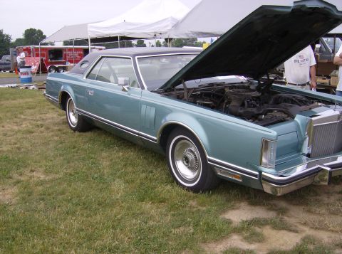 1970 Ford Ranchero - A teal 1977 Lincoln Continental Mark V coupe is displayed with its hood open, revealing the engine compartment.