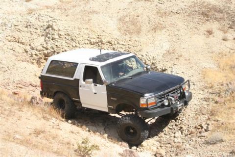 1994 Ford Bronco - This two-tone Ford Bronco is shown off-roading on a rocky, arid terrain.