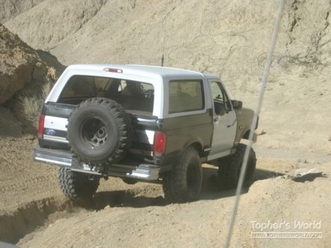 1994 Ford Bronco - This 1994 Ford Bronco navigates a dusty trail in a , arid environment.