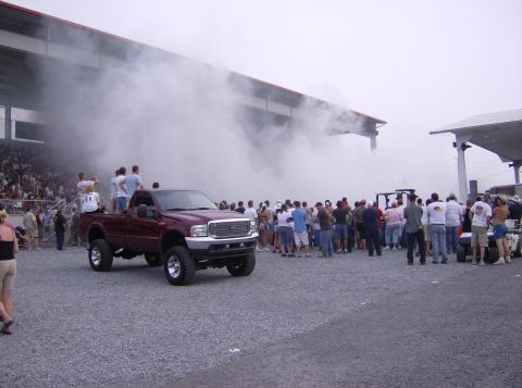 1970 Ford Ranchero - A crowd watches as a maroon pickup truck produces a large cloud of smoke.