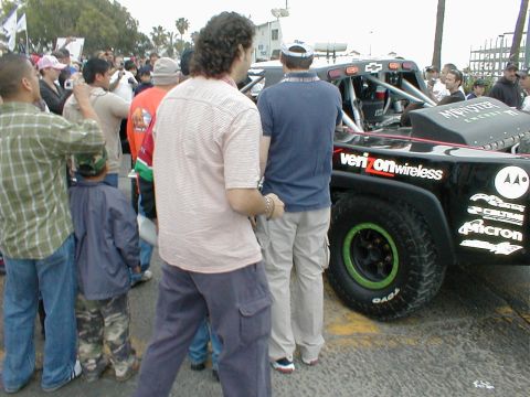1996 Ford Bronco - A crowd gathers around a custom off-road truck with sponsor logos visible on its side.