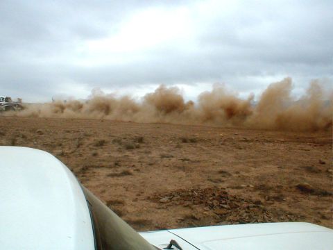 1996 Ford Bronco - Vehicles race across a desert landscape, creating massive dust clouds.