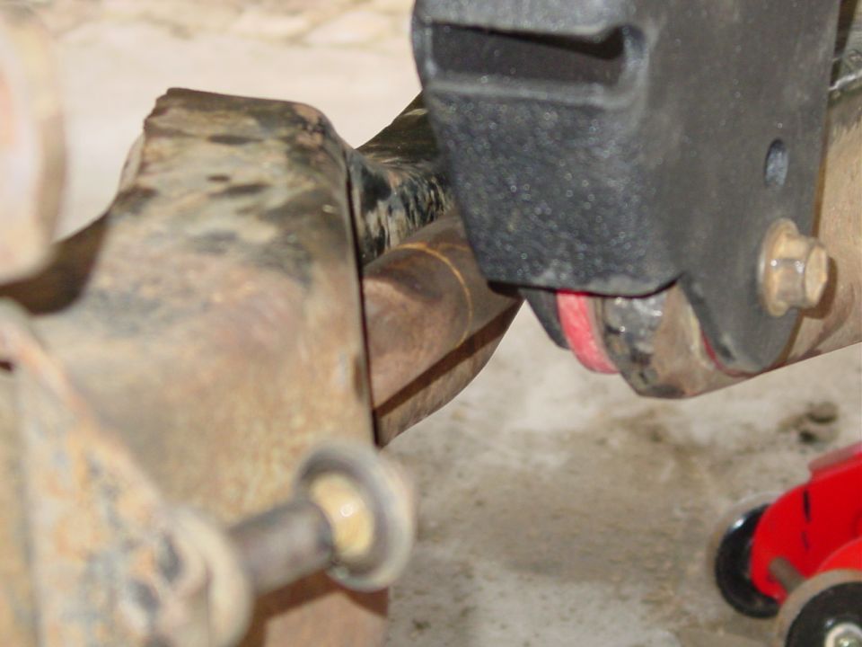 Close-up of a suspension component with a red bushing and metal bracket
