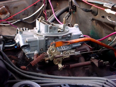 1992 Ford Mustang - A detailed view of a carburetor and surrounding engine components, with visible wiring and springs.