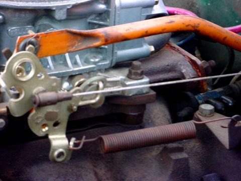 1992 Ford Mustang - This image shows a close-up view of a vehicle's carburetor linkage and throttle return spring.