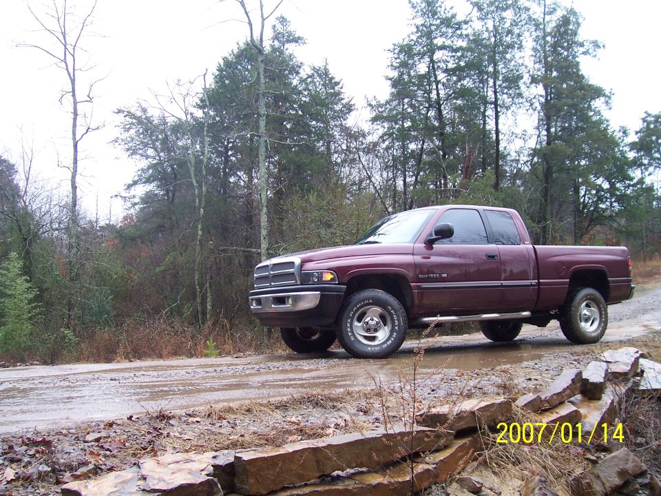 Maroon 2001 Dodge 1500 pickup truck on a muddy road