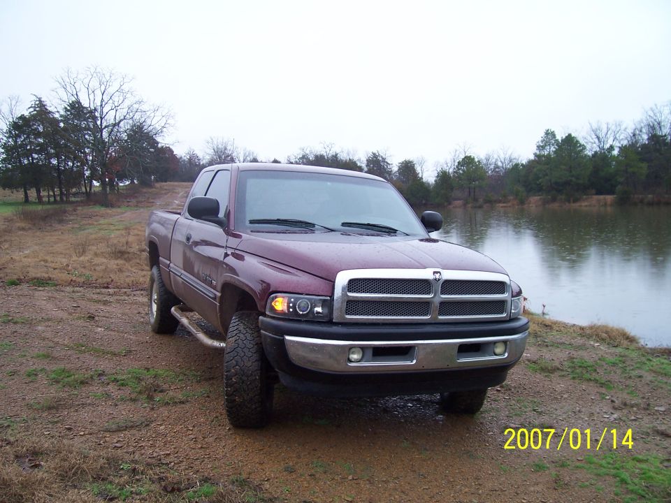 Maroon Dodge Ram pickup truck parked by a lake