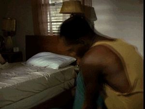 1991 Ford Bronco - A man is seen in a bedroom, leaning over a bed.