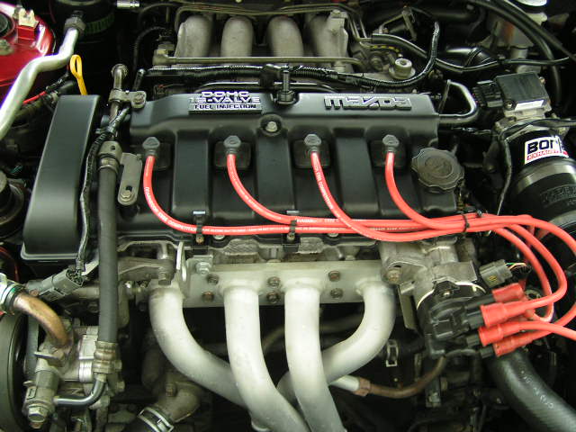 Engine bay with a Mazda engine, red spark plug wires, and a BOI intake