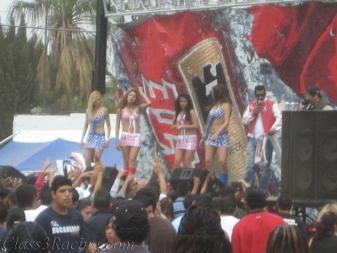 1990 Ford Bronco - Costumed dancers in red, white, and blue perform on an outdoor stage with a giant beer-can backdrop above a dense crowd.