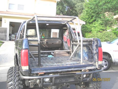 1994 Ford Bronco - This modified pickup truck features a substantial roll cage installed in the bed and cabin area.