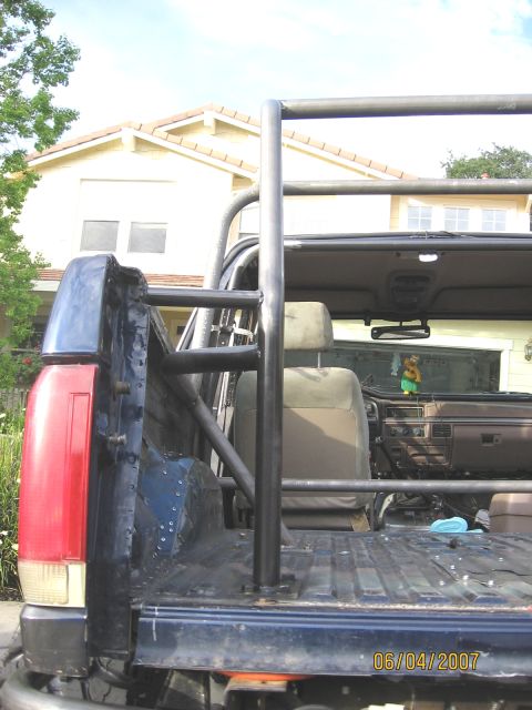 1994 Ford Bronco - The interior of a 1994 Ford Bronco shows a custom roll cage and a dated interior.