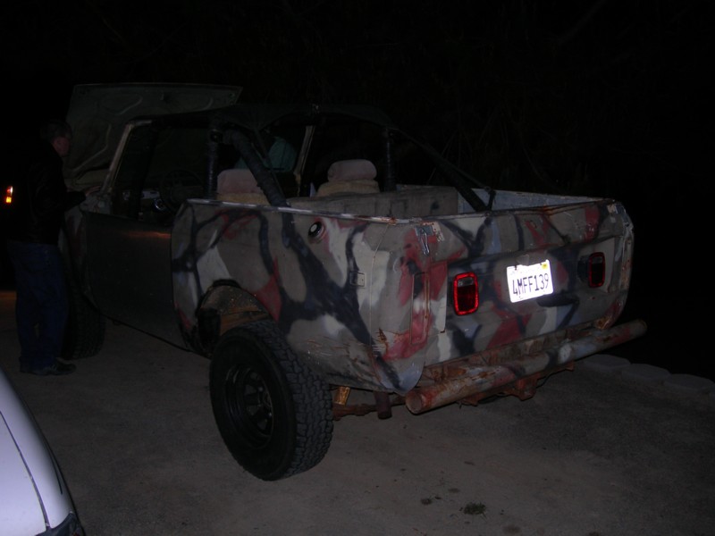 Camouflaged SUV with roll cage, rear view, rusty bumper, license plate LMF139