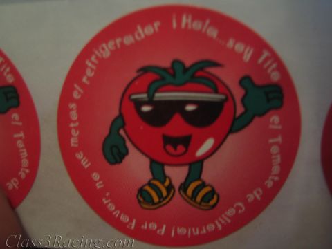 1990 Ford Bronco - round red sticker depicts a smiling cartoon tomato in sunglasses surrounded by Spanish lettering on a white sheet.