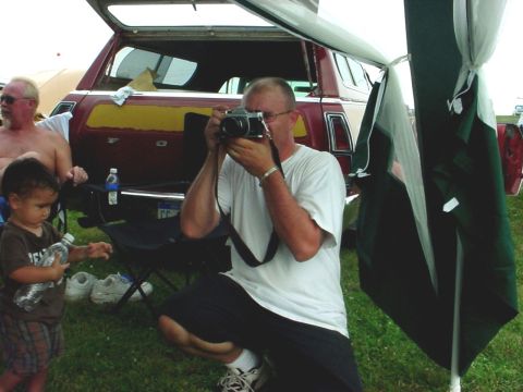 1992 Ford Mustang - A man photographs a station wagon while a child holds a water bottle.