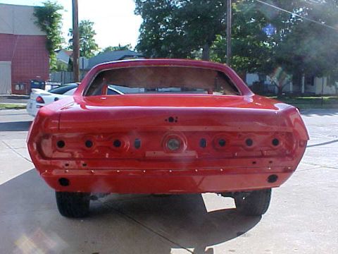 1967 Mercury Cougar - Rear view of a red 1967 Mercury Cougar body undergoing restoration, missing lights and bumper.