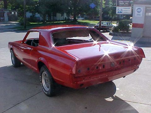 1967 Mercury Cougar - A red coupe sits outside a shop, appearing to be in the middle of a restoration project.