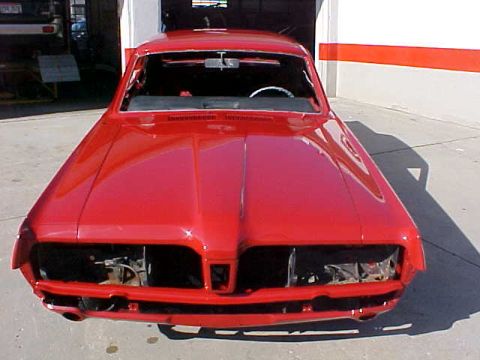 1967 Mercury Cougar - A red 1967 Mercury Cougar is shown from the front, undergoing restoration with its headlights removed.