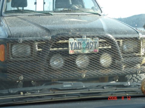 1993 Ford Bronco - This black truck features a heavy-duty brush guard with multiple auxiliary lights mounted behind a wire mesh.