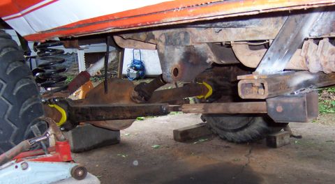 1978 Ford Bronco - The underside of a vehicle, possibly undergoing modifications, is shown with its suspension and differential components visible.
