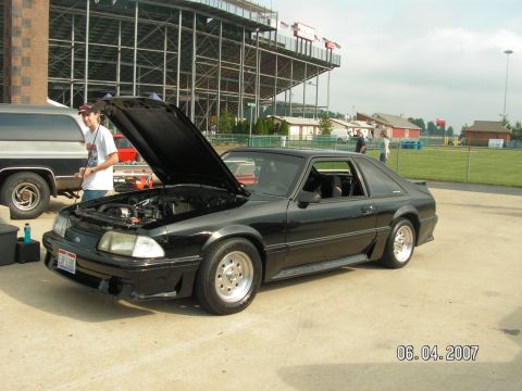 1988 Ford Mustang - A black 1988 Ford Mustang coupe is displayed with its hood open, revealing the engine bay.