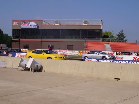 1988 Ford Mustang - Two cars line up at the starting line of a drag strip at Summit Motorsports Park.