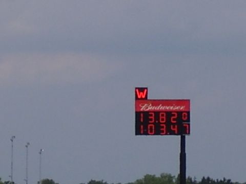 1988 Ford Mustang - A drag strip scoreboard displays racing times under a cloudy sky.