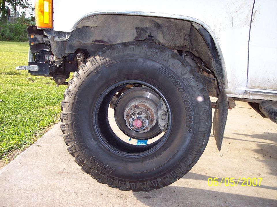 Front wheel, brake rotor, and fender of a white 1984 Toyota 4Runner