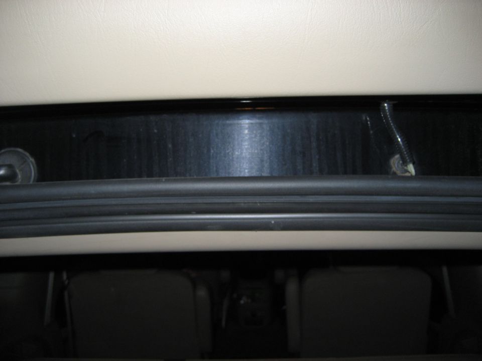 Interior view looking up at the headliner and rear window seal, with seats visible below