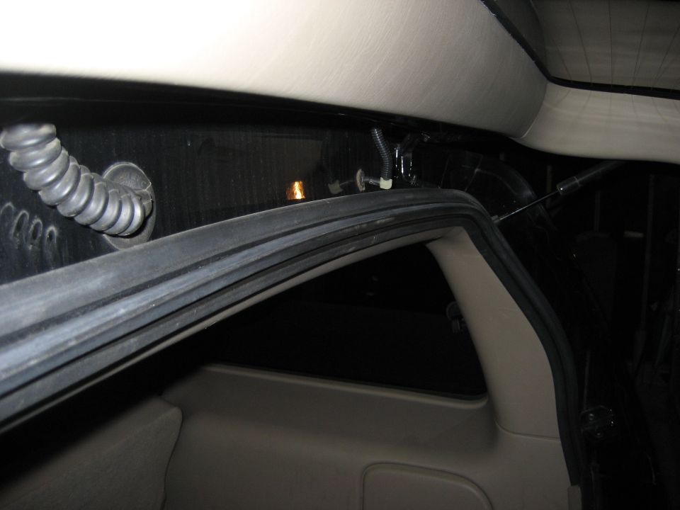 Inside the rear of a vehicle, showing the seal around the hatch opening and some wiring