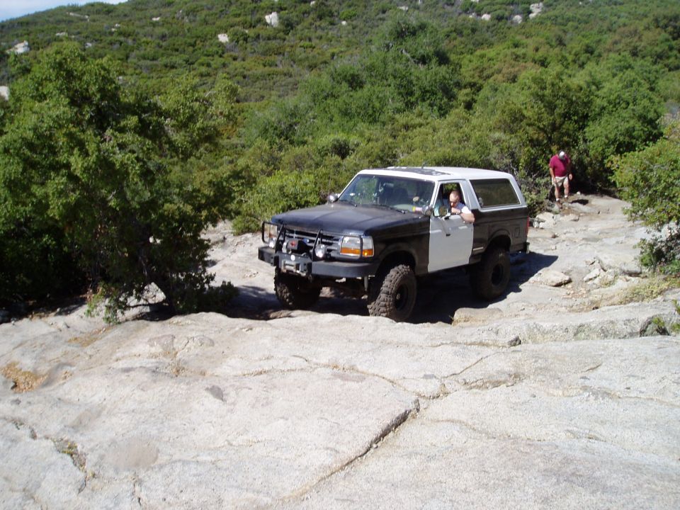 1994 Ford Bronco on rocky trail, black and white body
