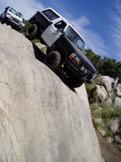1994 Ford Bronco - Two off-road vehicles, a 1994 Ford Bronco and a Jeep Wrangler, navigate a rocky incline.