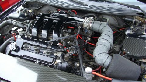 1990 Ford Probe - The engine bay features a V6 engine with a polished intake manifold and a custom exhaust wrap.