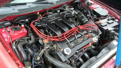 1990 Ford Probe - The engine bay of a 1990 Ford Probe, showing its V6 engine and various components.