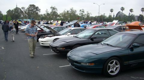 1990 Ford Probe - A row of Ford Probes are displayed at an outdoor car show, with one green coupe in the foreground.