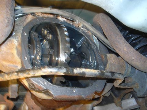 1996 Ford Crown Victoria - Close-up view of the differential gears, showing grease and some rust on the housing and exhaust pipe.