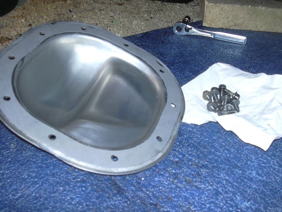 Differential cover and bolts with a ratchet on a blue surface