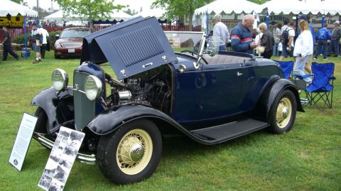 1990 Ford Probe - A classic dark blue convertible is displayed with its hood open, revealing the engine and wire wheels.