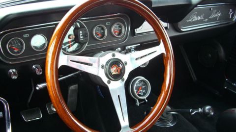 1990 Ford Probe - The interior of a 1965 Mustang Shelby GT350 features a classic wood-rimmed steering wheel and auxiliary gauges.
