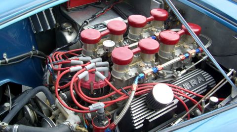 1990 Ford Probe - Close-up of a V8 engine bay dual carburetors and prominent 'COBRA' branding on the valve covers.