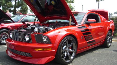 1990 Ford Probe - A red Ford Mustang, likely from the mid-2000s, is displayed with its hood and trunk open, revealing its engine and interior details.